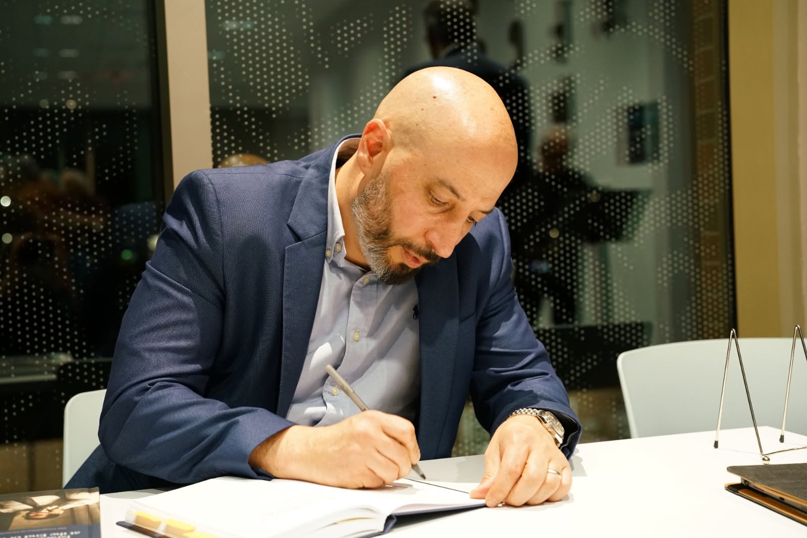 Eldad Ben Aharon signing a copy of his book